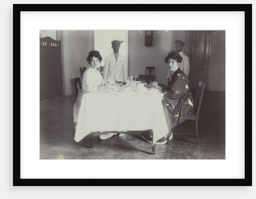 Group portrait of young women at the table with servants in the Dutch East Indies, indonesia by Anonymous