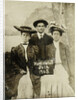 Portrait of a man and two women in front of a painted backdrop (tree, lake and mountains) and a sign that read 'Huntington FAIR 1905 by Anonymous