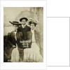 Portrait of a man and two women in front of a painted backdrop (tree, lake and mountains) and a sign that read 'Huntington FAIR 1905 by Anonymous