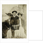 Portrait of a man and two women in front of a painted backdrop (tree, lake and mountains) and a sign that read 'Huntington FAIR 1905 by Anonymous