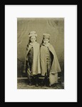 Portrait of two girls with hats and capes, standing in a studio setting by Anonymous