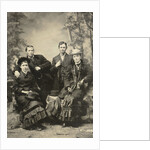 Two men and two women standing and sitting in front of a painted backdrop (forest) by Anonymous