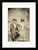 Portrait of a man and woman sitting in front of a painted backdrop (beach, sea and pier) by Anonymous