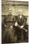 Portrait of an elderly man and woman sitting on a wooden wall or fence by Anonymous