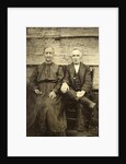 Portrait of an elderly man and woman sitting on a wooden wall or fence by Anonymous
