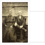 Portrait of an elderly man and woman sitting on a wooden wall or fence by Anonymous