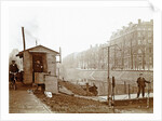 Men, presumably workers, and two cats at a jetty and a guardhouse along a canal by Anonymous