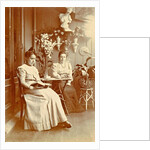 Two women sitting in a greenhouse, one reading by Anonymous