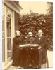 Two men and a woman sitting at home with a book on the table by Anonymous