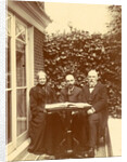 Two men and a woman sitting at home with a book on the table by Anonymous
