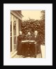 Two men and a woman sitting at home with a book on the table by Anonymous