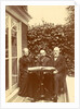 Two men and a woman sitting at home with a book on the table by Anonymous