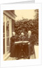 Two men and a woman sitting at home with a book on the table by Anonymous
