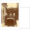 Two men and a woman sitting at home with a book on the table by Anonymous