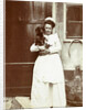 Maid with a dachshund in her arms at an outside tap by Anonymous