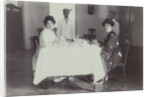 Group portrait of young women at the table with servants in the Dutch East Indies, indonesia by Anonymous