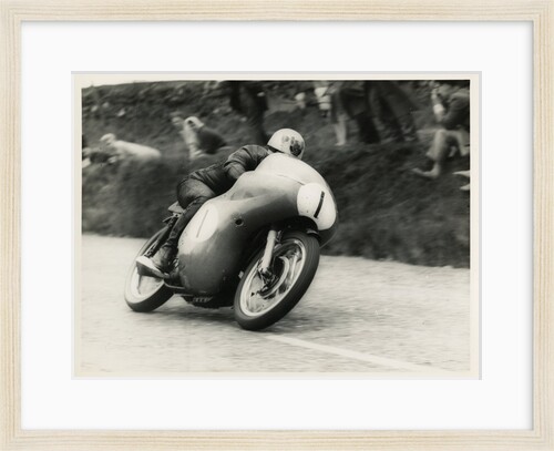 Bob McIntyre, TT (Tourist Trophy) rider, riding 499cc Norton (number 1) over the Mountain by T.M. Badger