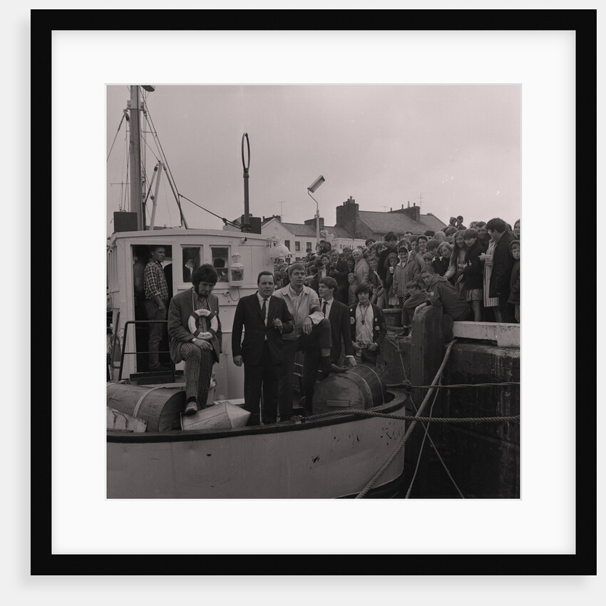 Radio Caroline disc jockeys Dave Lee Travis (on left with life ring) and Tony Prince (right with badges on jacket) on boat, Ramsey harbourside by Manx Press Pictures