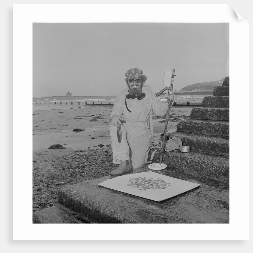 Metal detectorist on Douglas beach by Manx Press Pictures