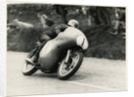 Bob McIntyre, TT (Tourist Trophy) rider, riding 499cc Norton (number 1) over the Mountain by T.M. Badger