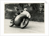 Bob McIntyre, TT (Tourist Trophy) rider, riding 499cc Norton (number 1) over the Mountain by T.M. Badger