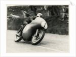 Bob McIntyre, TT (Tourist Trophy) rider, riding 499cc Norton (number 1) over the Mountain by T.M. Badger