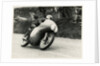 Bob McIntyre, TT (Tourist Trophy) rider, riding 499cc Norton (number 1) over the Mountain by T.M. Badger