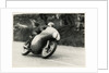 Bob McIntyre, TT (Tourist Trophy) rider, riding 499cc Norton (number 1) over the Mountain by T.M. Badger
