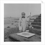 Metal detectorist on Douglas beach by Manx Press Pictures