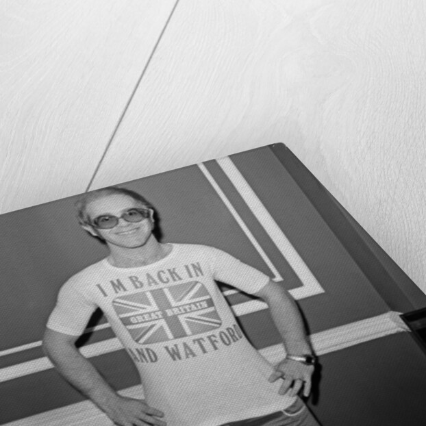 Elton John returns from America to announce that he is back in Britain for good. by Carl Bruin