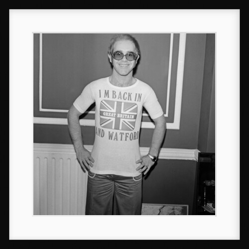 Elton John returns from America to announce that he is back in Britain for good. by Carl Bruin