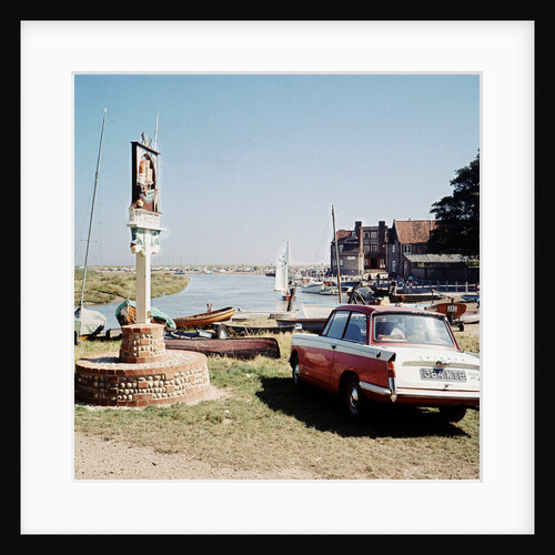 A Triumph hearld car parked next to a signpost at Blakeney by Anonymous