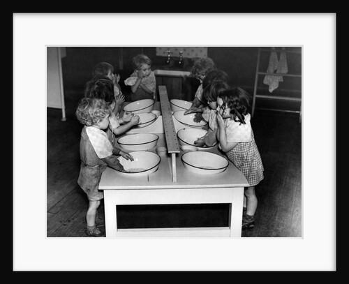 Young children washing themselves in enamal basins during World War Two by Staff