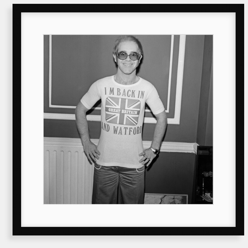 Elton John returns from America to announce that he is back in Britain for good. by Carl Bruin