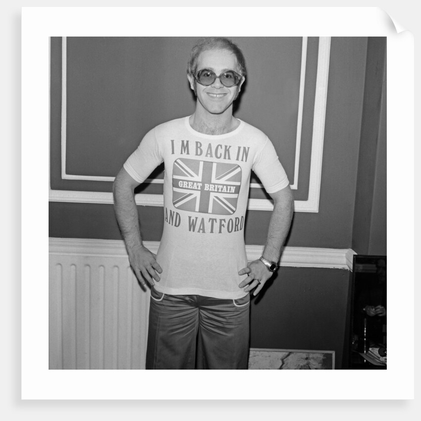 Elton John returns from America to announce that he is back in Britain for good. by Carl Bruin