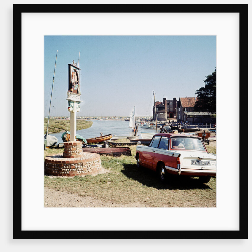 A Triumph hearld car parked next to a signpost at Blakeney by Anonymous