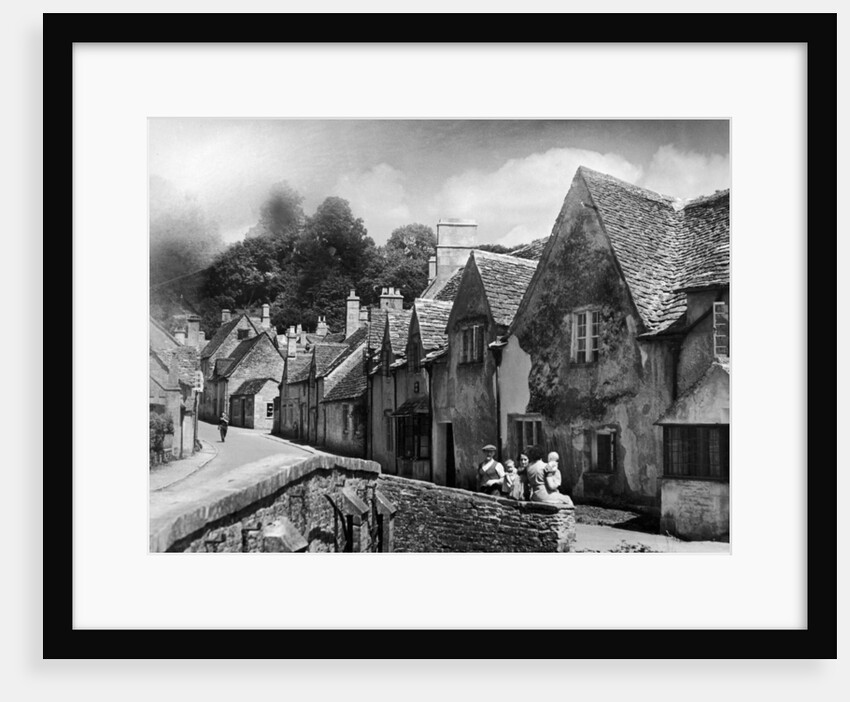 A family takes a rest on a stone wall in a Cotswold village in Gloucestershire by Anonymous