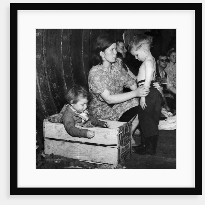 A mother tends to her young son in an underground bomb shelter during an air raid by Staff