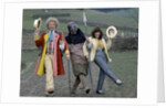 Colin Baker with Nicola Bryant who plays Perpugilliam "Peri" Brown during filming at Butser Ancient Farm Project, Butser Hill, Hampshire for the story The Mysterious Planet, part of the larger Trial of A Time Lord narrative. 10th April 1986. by Anonymous