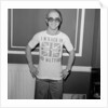 Elton John returns from America to announce that he is back in Britain for good. by Carl Bruin