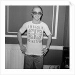 Elton John returns from America to announce that he is back in Britain for good. by Carl Bruin