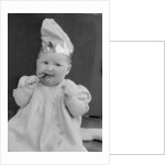 Baby wearing a party hat and eating a Cadbury chocolate finger by Staff