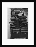 Tourists sit underneath their umbrellas on the top deck of an open top bus by Kent Gavin
