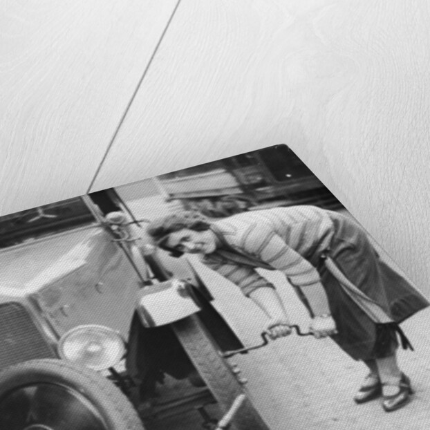 Ivy Cummings changing a tyre on a 1925 Singer 10/26, London, c1925 by Unknown