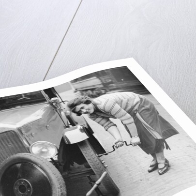 Ivy Cummings changing a tyre on a 1925 Singer 10/26, London, c1925 by Unknown