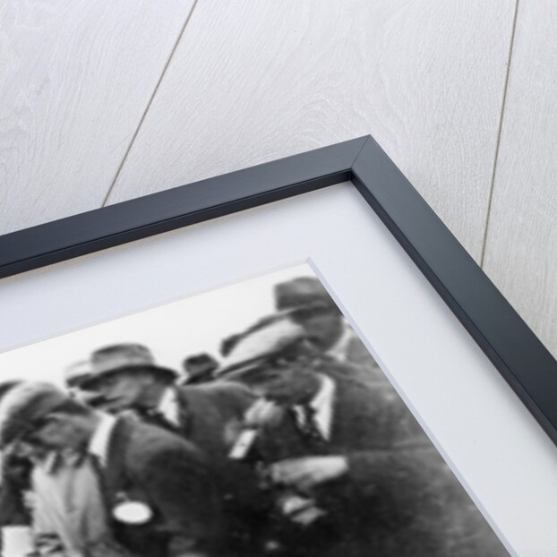 Gordon Taylor in a racing car surrounded by a crowd of men by Unknown