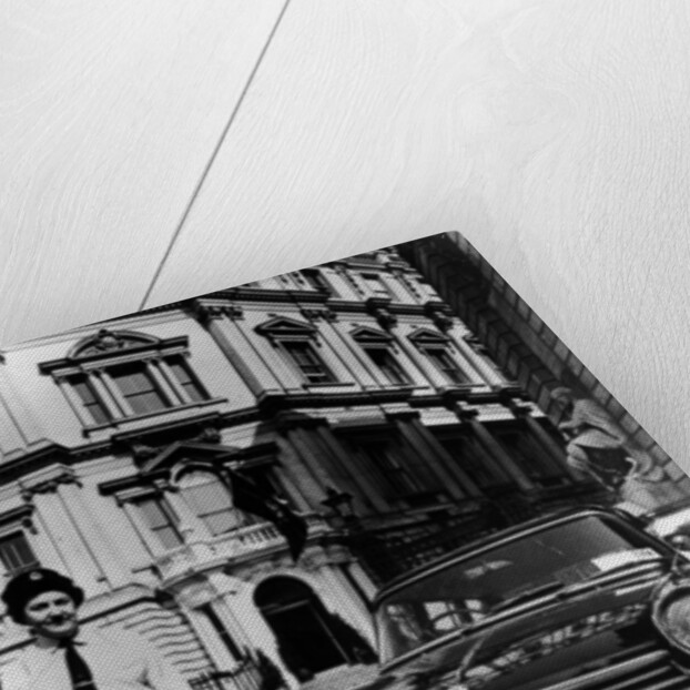 Female chauffeur standing by a 1964 Morris Oxford, 1964 by Unknown