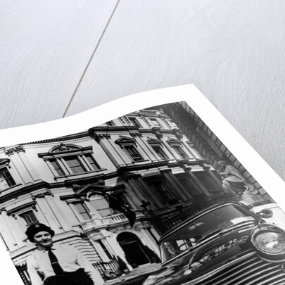 Female chauffeur standing by a 1964 Morris Oxford, 1964 by Unknown