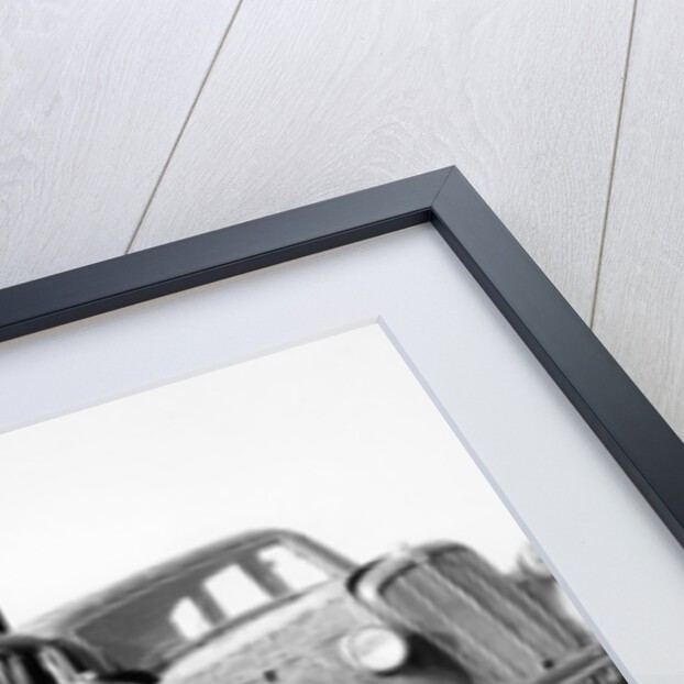 Old cars piled up in a scrapyard, Britain by Unknown