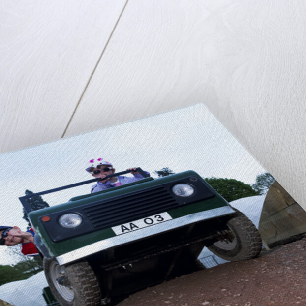 Child driving a toy Land Rover by Unknown